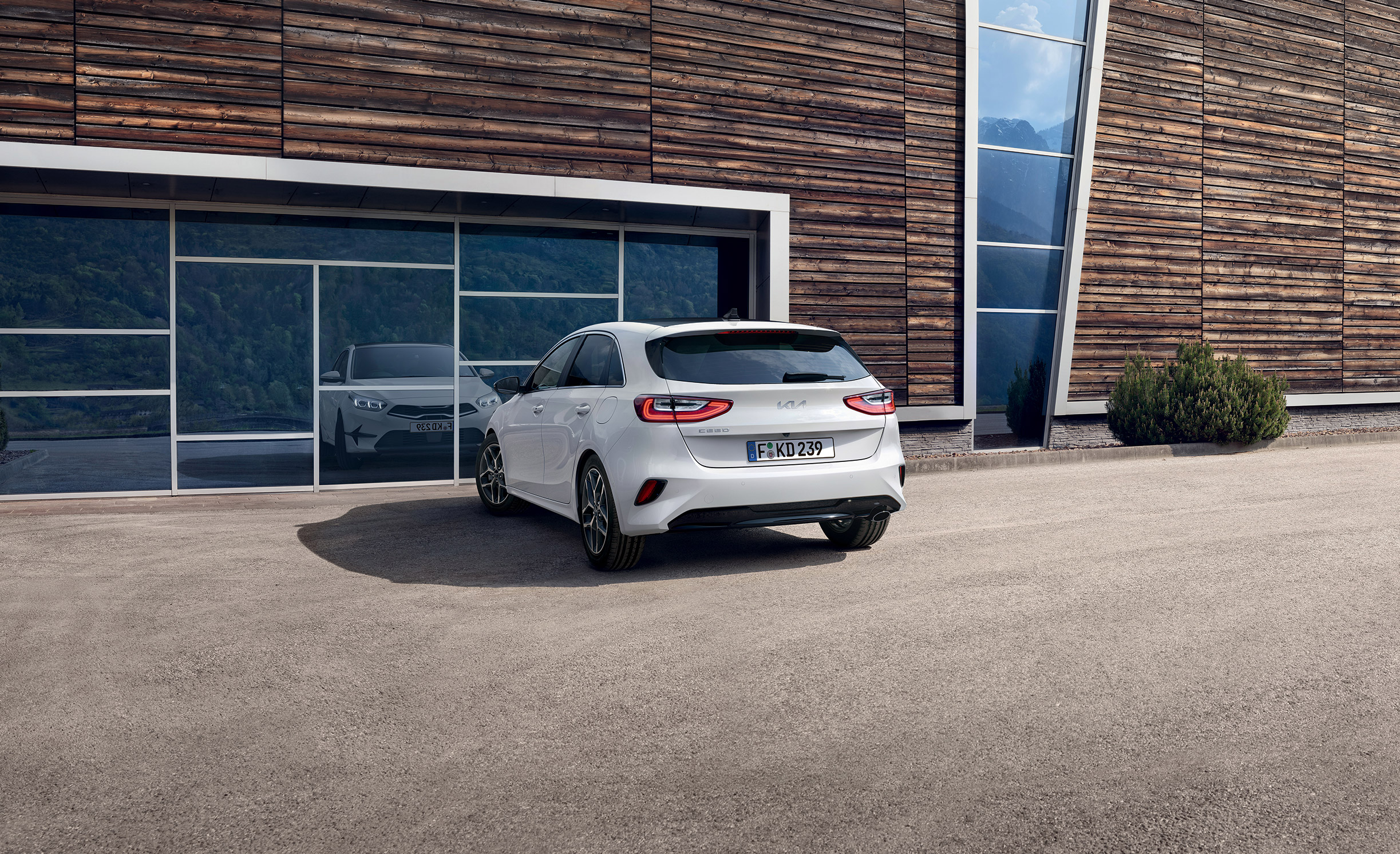 Weißer Kia Ceed vor einem Gebäude zur Modellpräsentation